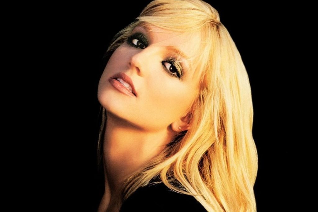 Foto colorida de Britney Spears no início da carreira em fundo preto - Metrópoles
