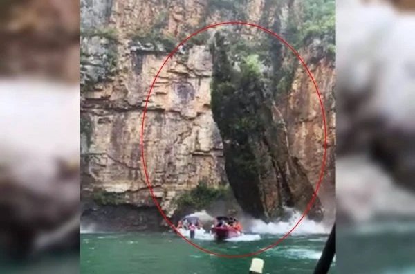 Na imagem colorida, rochas deslizam e caem em cima de lanchas com pessoas
