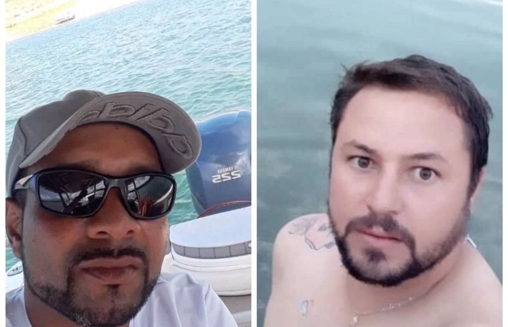 Na imagem colorida, dois homens dividem uma montagem. O da esquerda usa bone e oculos de sol e o da direita está sem blusa e olha atentamente para a camera
