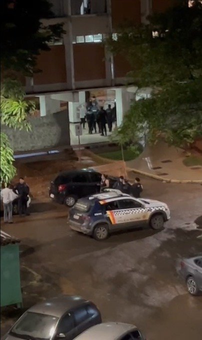 viatura da polícia estacionada, com agentes fora do carro