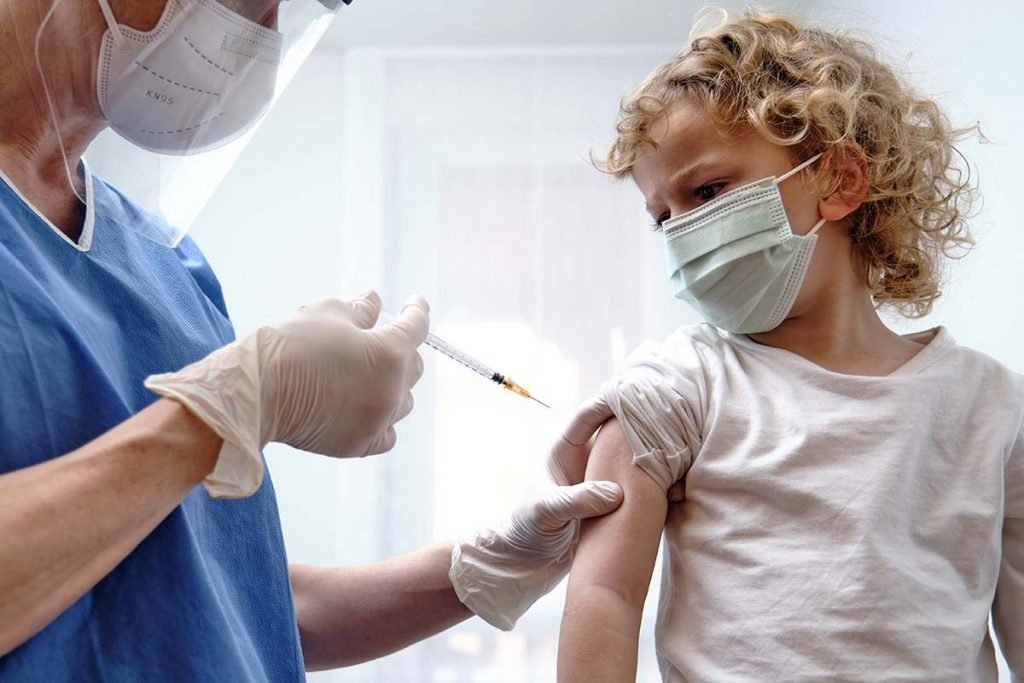 Médica dando vacina covid-19 para uma criança