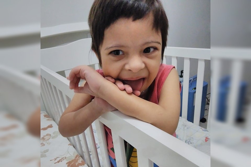 Criança com síndrome de Down dentro de berço