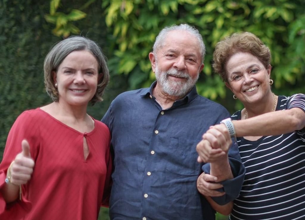 Presidente do PT, Gleisi Hoffmann, em encontro com os ex-presidentes Lula e Dilma Rousseff.  Eles lamentam em foto e dam as mãos - Metrópoles