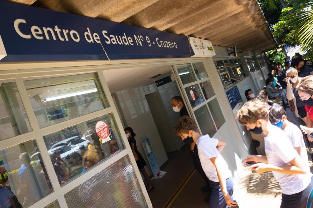 Crianças entrando em porta de Centro de Saúde