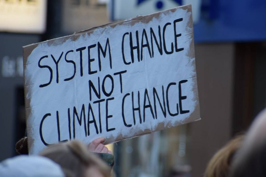 Cartaz com os dizeres mudança do sistema não mudança climática em inglês