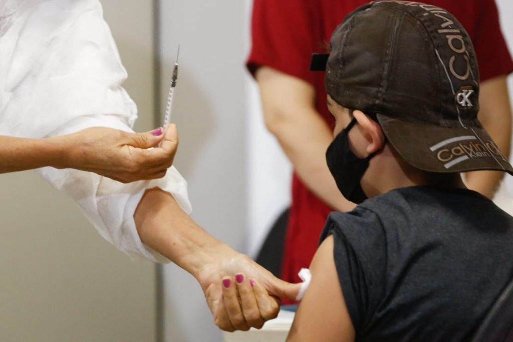 Criança recebe cuidado após tomar vacina contra Covid-19 em Goiânia, Goiás
