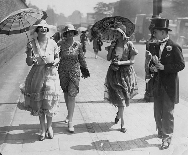 Mulheres andando na rua nos anos 1920 com roupa da época