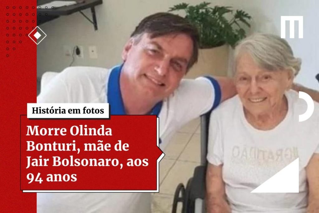 Na imagem colorida, um homem e uma mulher estão posicionados no centro. Os dois têm cabelos curtos e grisalhos, usam camiseta e bermuda e sorriem para a camera