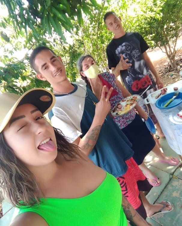 Menina de boné e língua para fora, dois homens e uma mulher atrás