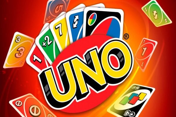 muitos cartões de jogo uno coloridos sobre fundo vermelho. uno é