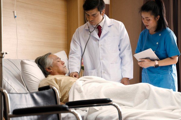 A doctor and a nurse accompany the hospitalized elderly