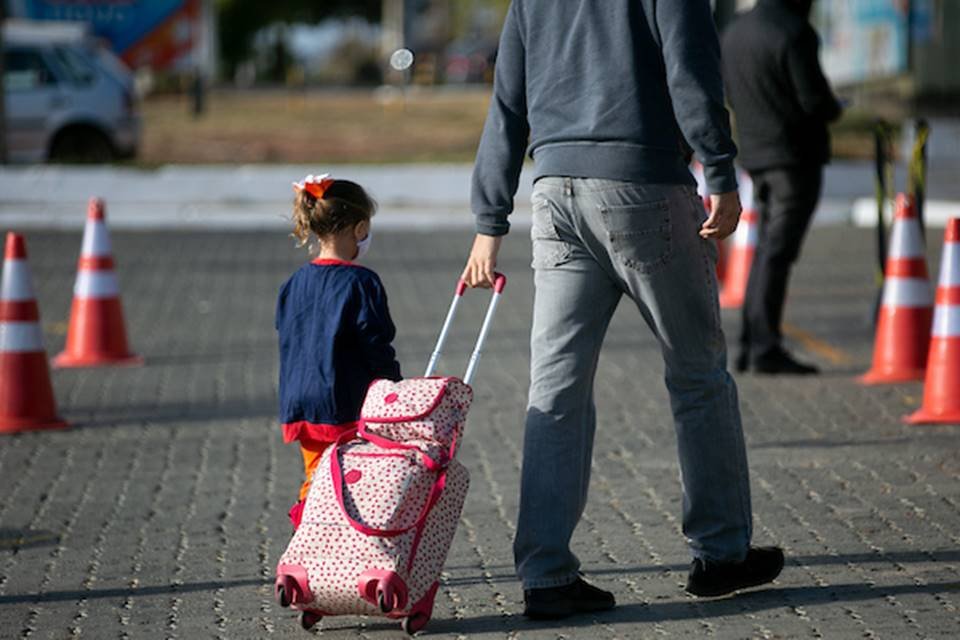Aluna indo para a escola com o responsável