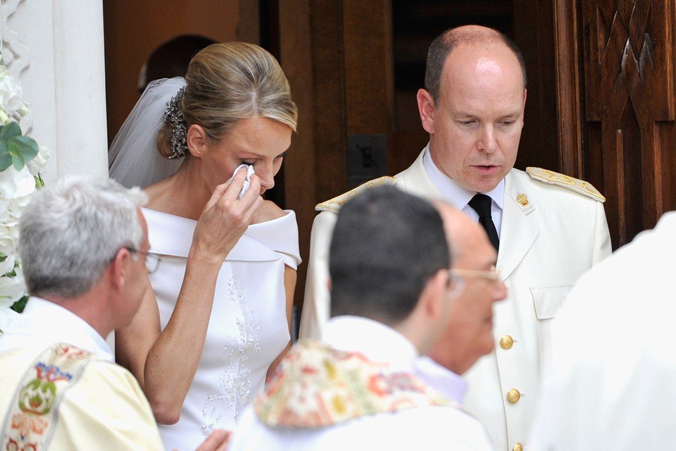 Mulher vestida de noiva ao lado de homem com terno branco