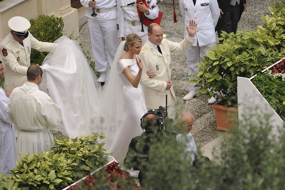 Mulher vestida de noiva ao lado de homem com trajes militares