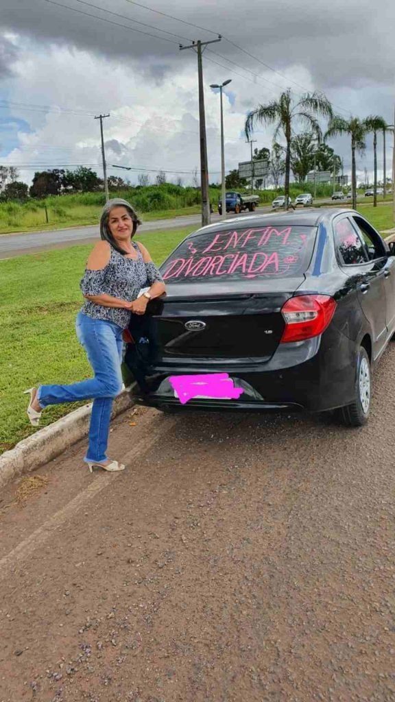 Mulher em pé ao lado de carro