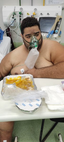 homem em cama com alimento em bandeja na frente dele