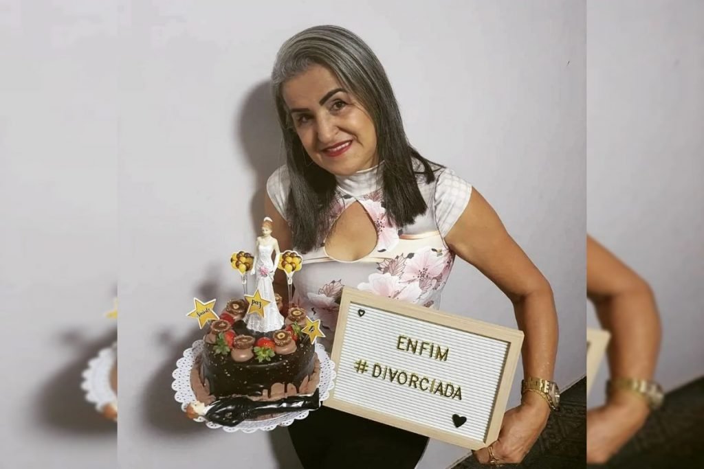 Mulher segura bolo e placa