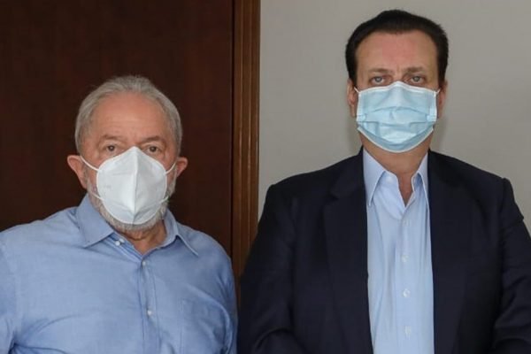 Lula e Gilberto Kassab (PSD) posam para foto. Ambos usam máscara, camisa social e olham sérios para frente, lado a lado - Metrópoles