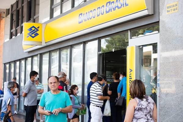 Imagem colorida mostra pessoas na entrada de agência bancária do banco do Brasil - Metrópoles