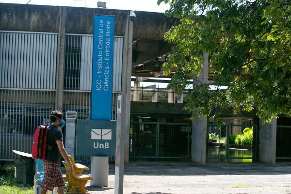 Aluno da UnB caminha em frente a entrada de bloco