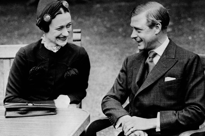Fotografia em preto e branco de casal sentando à mesa sorrindo