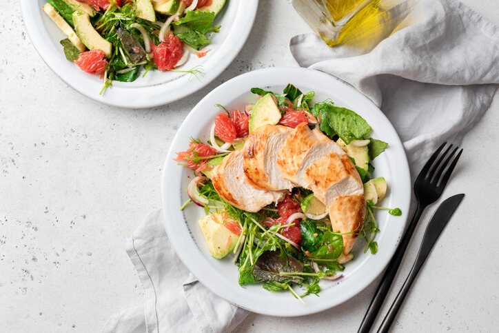 In the color image, meat is on a plate on the table.