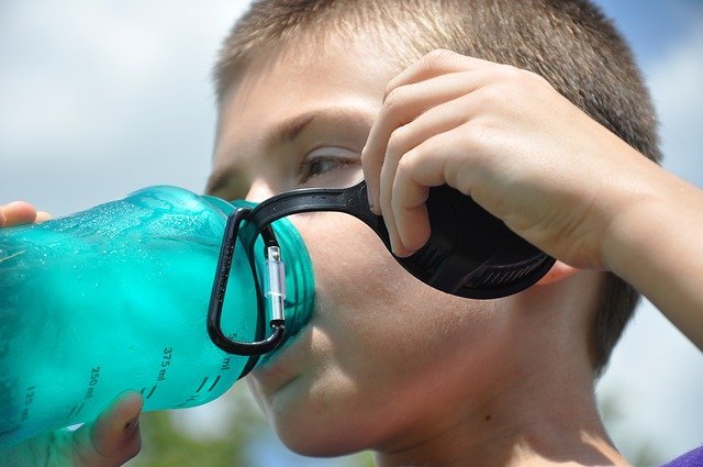 Forografia colorida de menino bebendo água