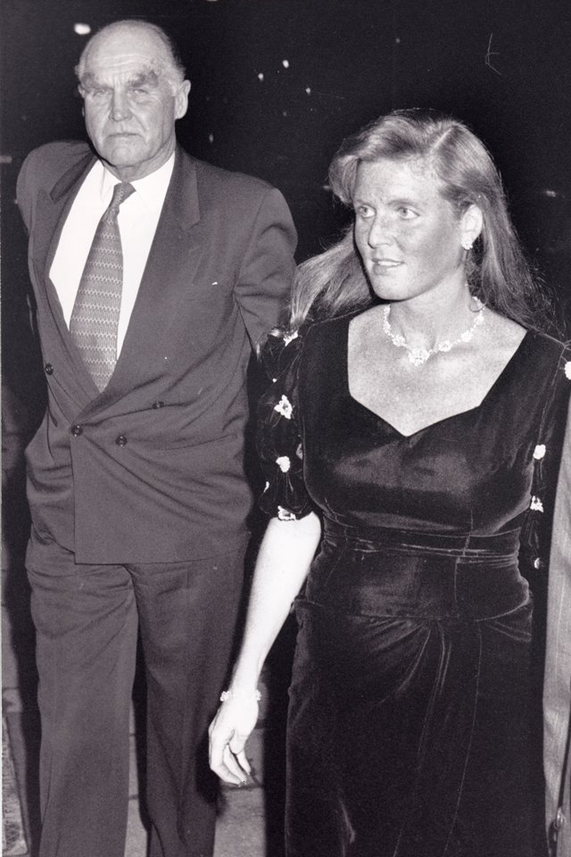 Foto em preto e branco. Homem alto e de terno ao lado de mulher com vestido preto