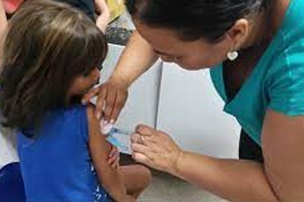 A color photograph of a child being vaccinated