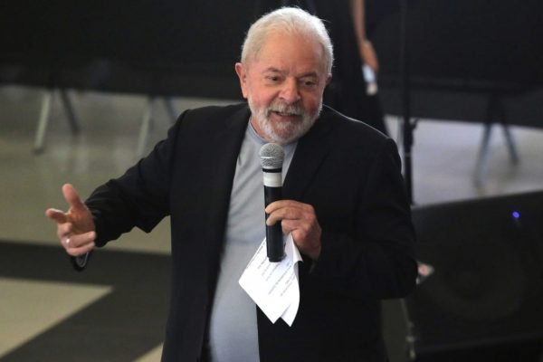 Lula discursa no sindicato dos metalúrgicos no ABC. Ele usa terno e camiseta, tem um microfone e folhas na mão e gesticula - Metrópoles