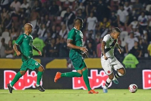 Na foto temos dois jogadores do boa vista correndo e na frente deles um jogador do vasco correndo com a bola