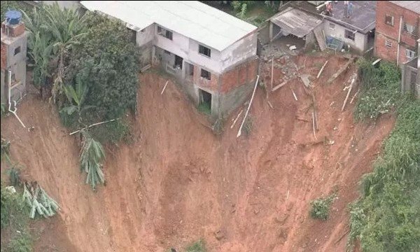 Na imagem colorida, a lama cobre as casas e as árvores.