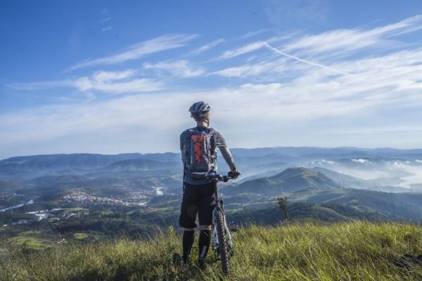 Homem de bicicleta com paisagem ao fundo