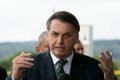 Bolsonaro fala na entrada do Palácio da Alvorada. Ele gestícula, usa terno e gravata e tem expressão séria - Metrópoles
