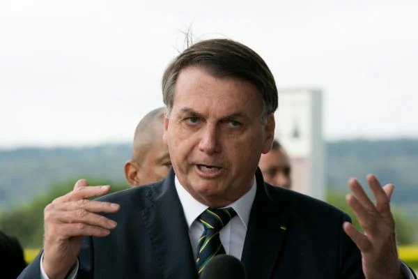 Bolsonaro fala na entrada do Palácio da Alvorada. Ele gestícula, usa terno e gravata e tem expressão séria - Metrópoles