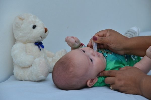 Foto colorida de um bebê durante campanha de vacinação - Metrópoles