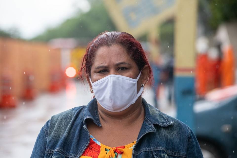 Mulher com jaqueta jeans e máscara protetora no rosto