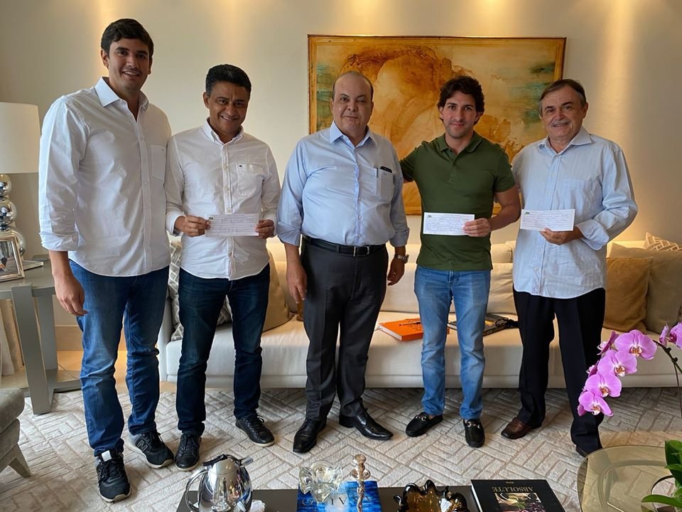 Homens de terno em sala olhando para foto