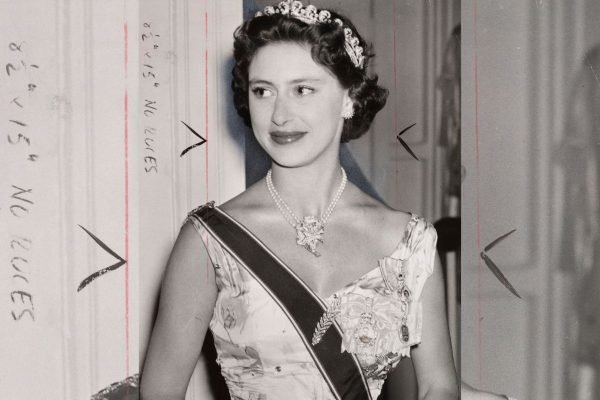 Foto em preto e branco de mulher com coroa, joias e faixa
