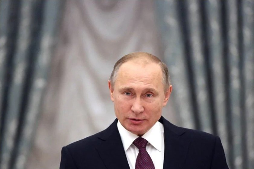 De frente, Vladimir Putin habla en un acto con fondo gris en la parte de atrás - Metropolis