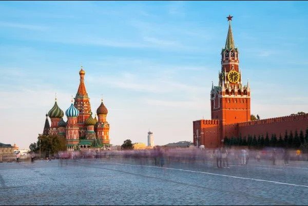 Plaza Roja con gran movimiento de gente durante el día.  Al fondo se puede ver el Kremlin, la sede del gobierno ruso, en Moscú - Metropolis