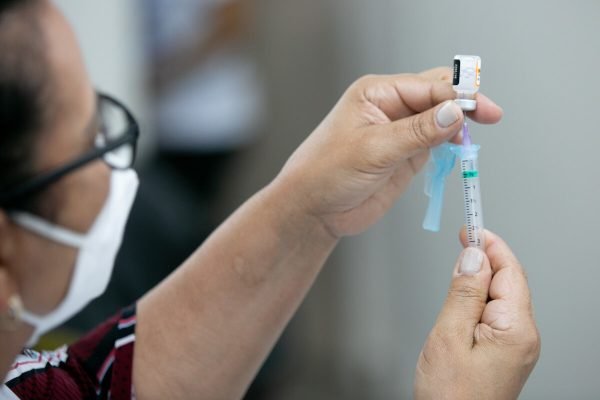 enfermeia retira vacina de frasco