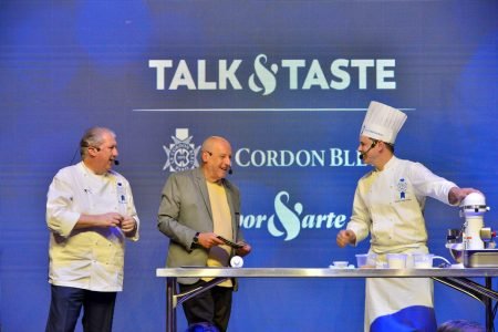 na foto temos tres chefs em um palco