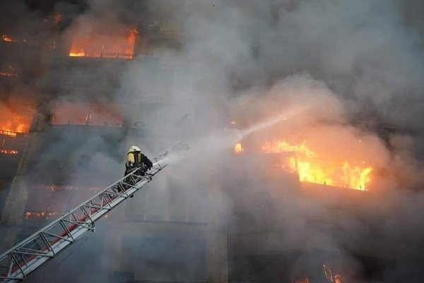Bombeiros tentando apagar chamas de prédios bombardeado por russos