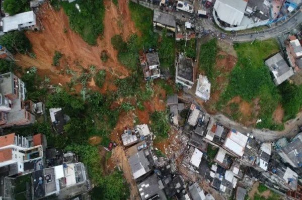 Na imagem colorida, lama está em cima de casas e arvores