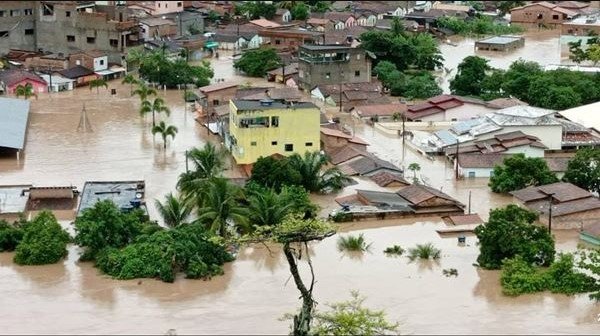 Na imagem colorida, lama está em cima de casas e arvores