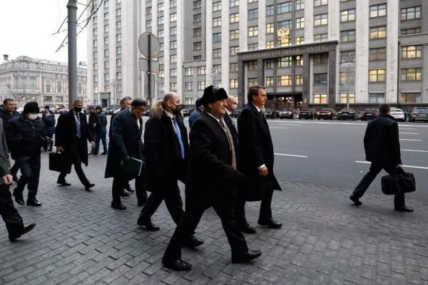 Presidente Bolsonaro anda acompanhado de comitiva pelas ruas Moscou, na Rússia. Ele usa sobretudo e está sem máscara - Metrópoles