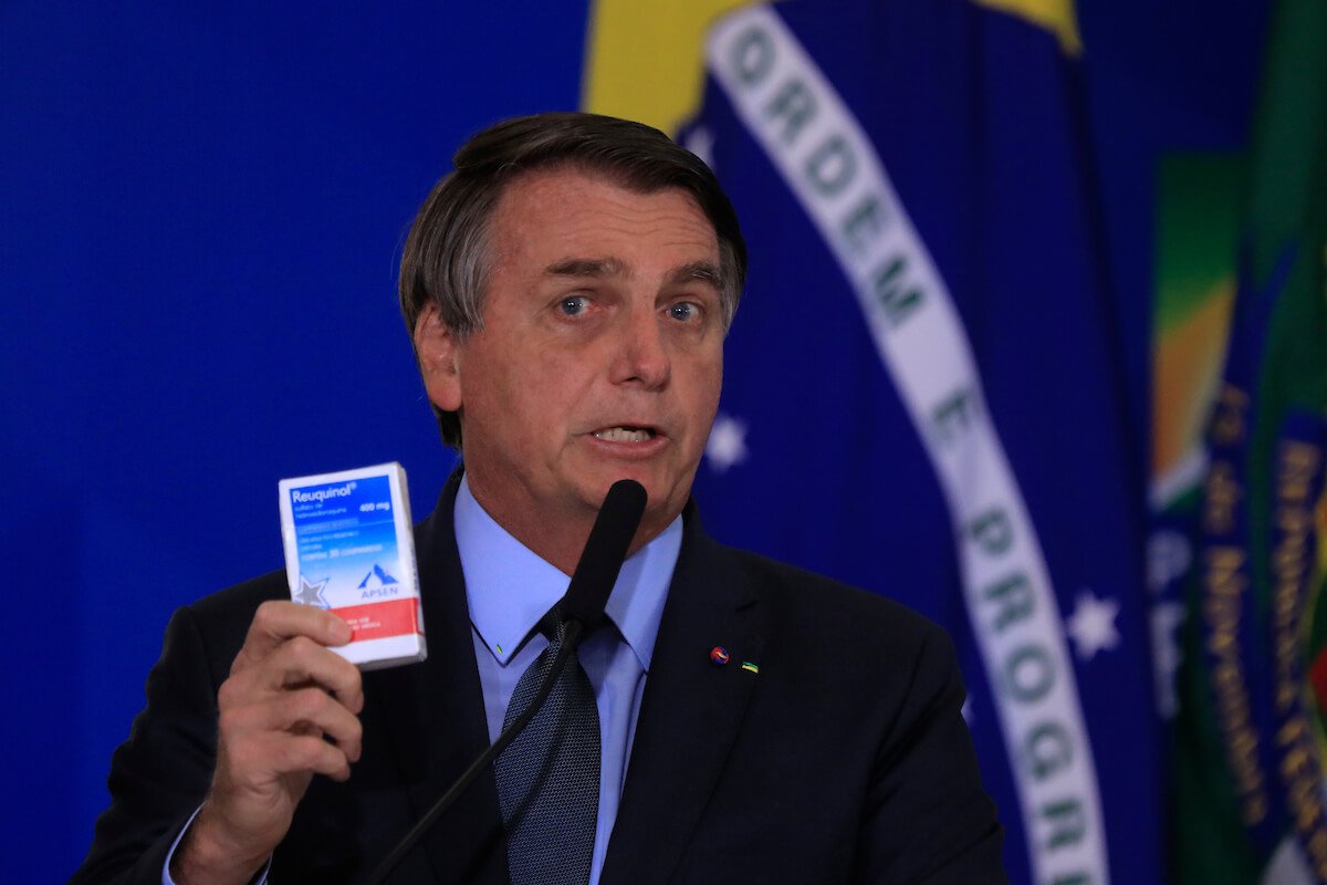 Presidente Bolsonaro segura caixa de hidroxicloroquina enquanto discursa. Ele é branco, usa terno e mostra a caixa de remédio numa das mãos enquanto fala ao microfone - Metrópoles