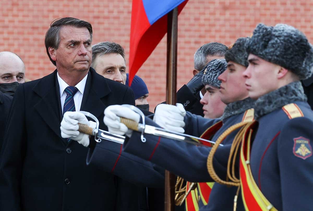 Bolsonaro participa de evento de homenagem ao Soldado Anônimo em Moscou. Ele usa roupa de frio e ao seu lado soldados russos vestidos em uniformes militares prestam continência - Metrópoles