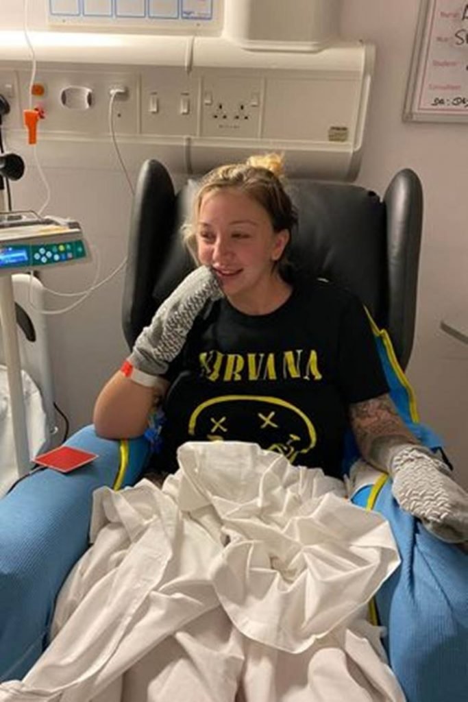 Mulher sentada em cama de hospital